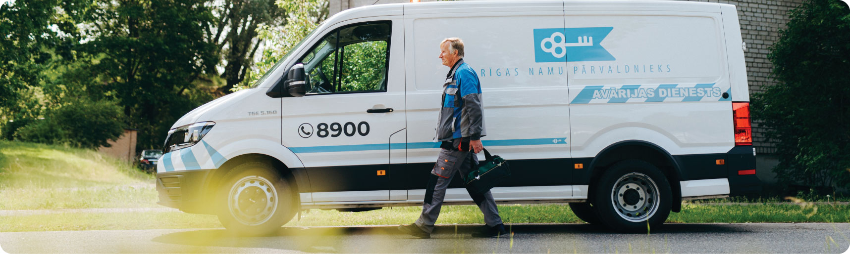 Rīgas namu pārvaldnieka avārijas dienesta darbinieks pie dienesta mašīnas