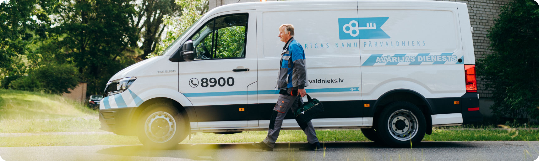 Rīgas namu pārvaldnieka avārijas dienesta darbinieks pie dienesta mašīnas
